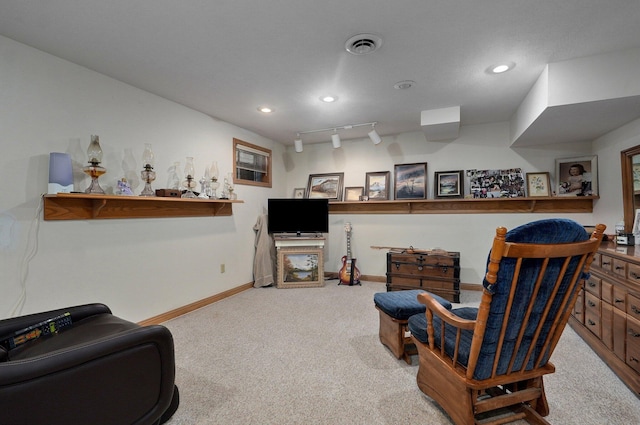 living area with light carpet and track lighting