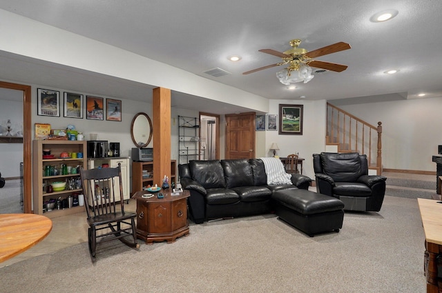 carpeted living room featuring ceiling fan and a textured ceiling