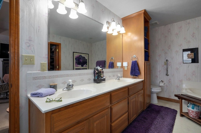 bathroom featuring tasteful backsplash, vanity, a chandelier, and toilet