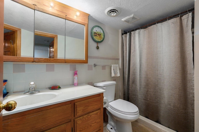 bathroom featuring vanity, toilet, a textured ceiling, tile walls, and curtained shower