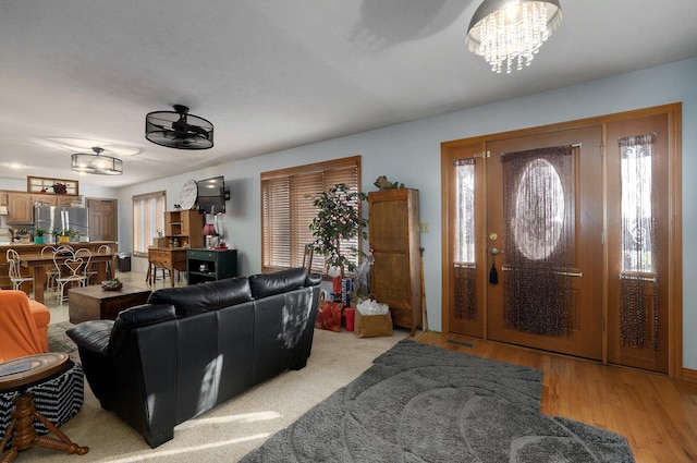 living room with light hardwood / wood-style flooring and an inviting chandelier