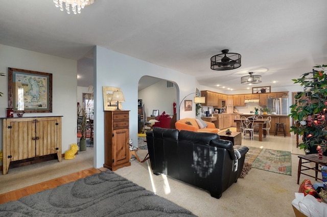 carpeted living room with a notable chandelier