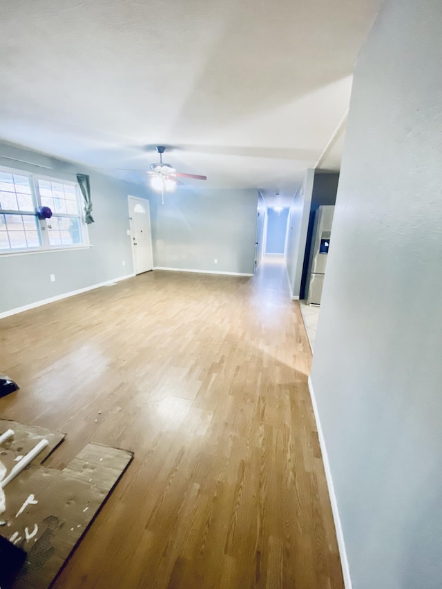 unfurnished living room featuring ceiling fan and light hardwood / wood-style flooring