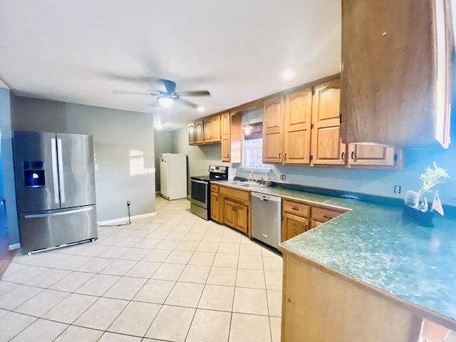 kitchen featuring light tile patterned floors, stainless steel appliances, ceiling fan, and sink