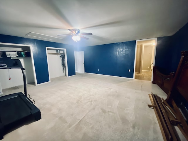 exercise room featuring ceiling fan and light colored carpet