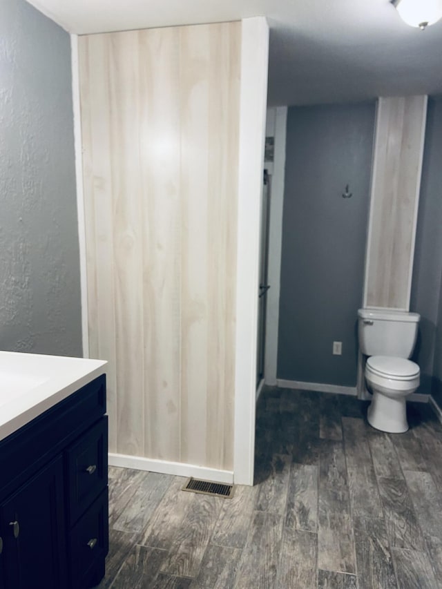 bathroom featuring vanity, toilet, and a shower