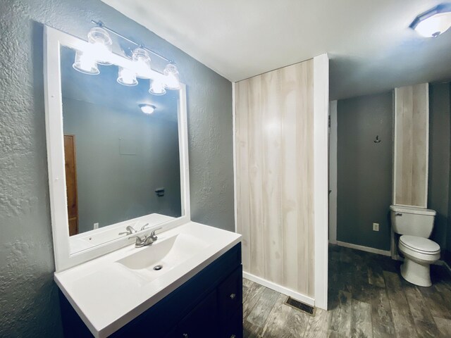 bathroom featuring hardwood / wood-style floors, vanity, and toilet