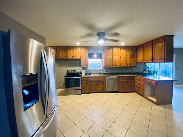 kitchen featuring ceiling fan, sink, light tile patterned floors, and stainless steel appliances