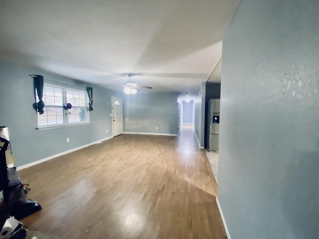 unfurnished living room with light hardwood / wood-style flooring and ceiling fan