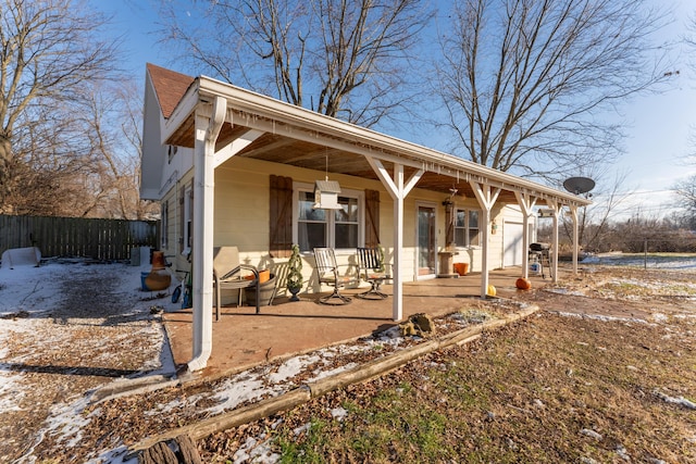 snow covered property with covered porch