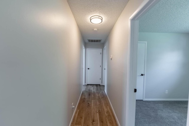 corridor featuring hardwood / wood-style flooring and a textured ceiling