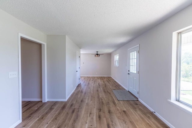 foyer featuring light wood-type flooring, a textured ceiling, and ceiling fan