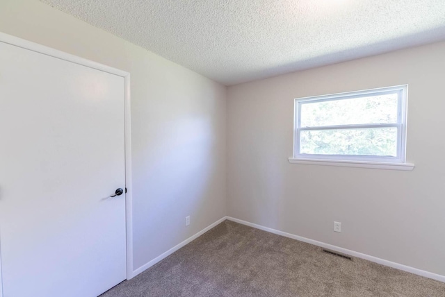 empty room featuring carpet flooring and a textured ceiling