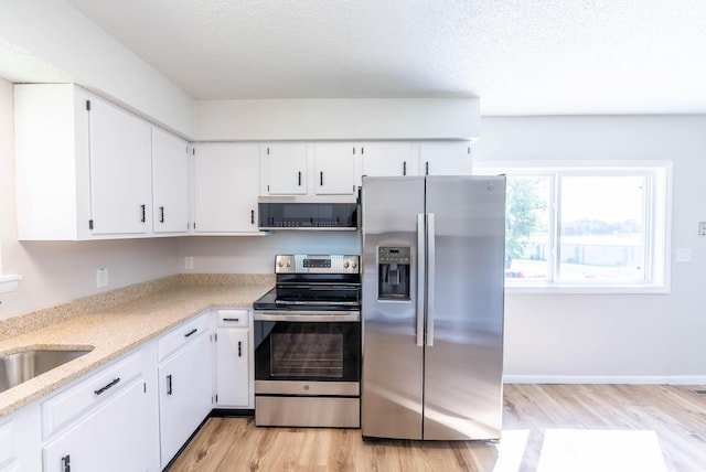 kitchen with sink, light hardwood / wood-style flooring, white cabinets, and appliances with stainless steel finishes