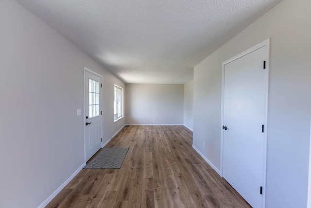 interior space with a textured ceiling and light hardwood / wood-style flooring