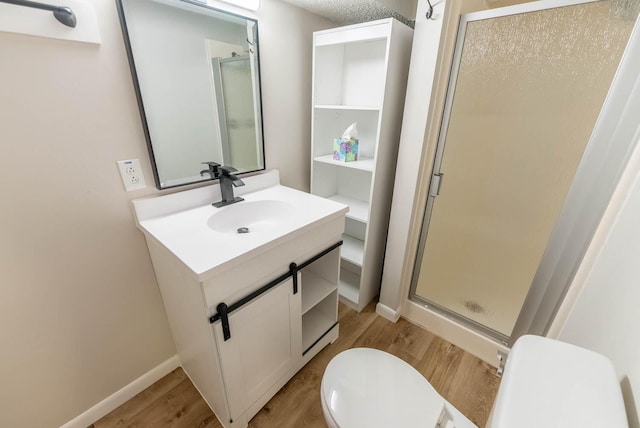 bathroom with hardwood / wood-style floors, vanity, toilet, and an enclosed shower