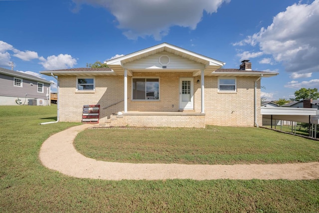 rear view of property with a lawn and a carport