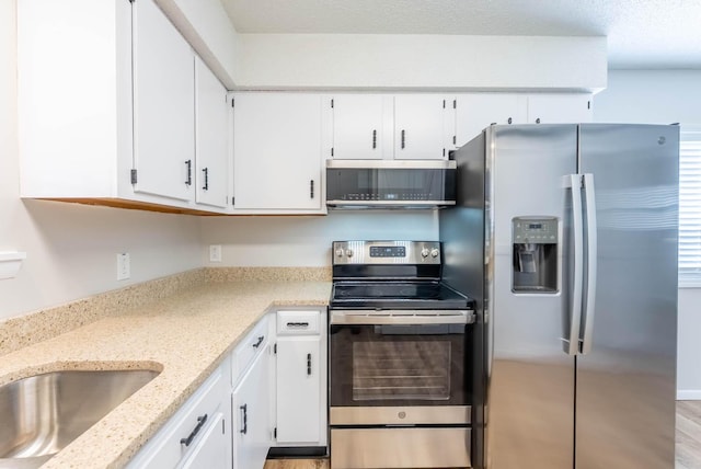 1610 Good Hard Dr, West Plains, MO 65775 - kitchen with appliances with stainless steel finishes, white cabinetry, and light stone counters