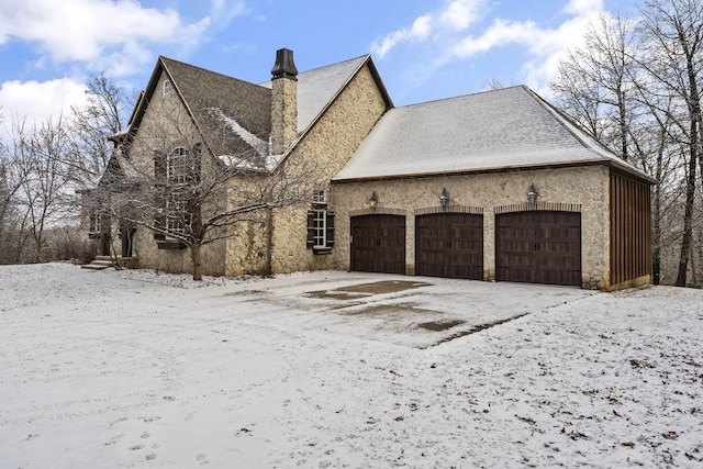 view of snow covered exterior featuring a garage