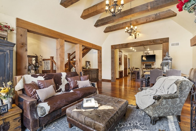 living room with lofted ceiling with beams, dark hardwood / wood-style flooring, and an inviting chandelier