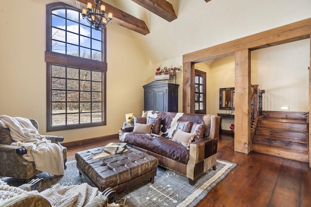 living room featuring beam ceiling, a towering ceiling, a wealth of natural light, and dark wood-type flooring