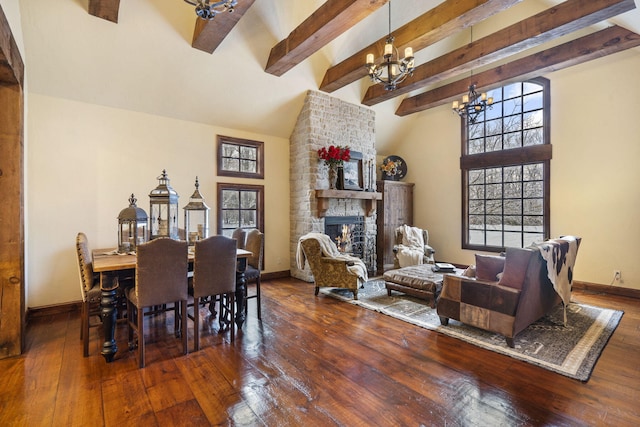 dining area with beamed ceiling, dark hardwood / wood-style flooring, a fireplace, and a chandelier