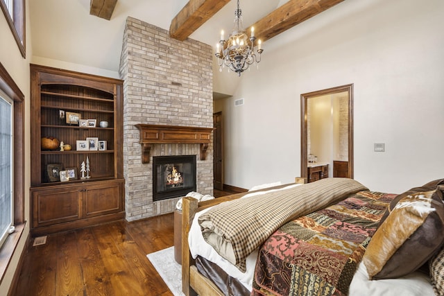 bedroom featuring dark wood-type flooring, a high ceiling, a brick fireplace, a notable chandelier, and beam ceiling