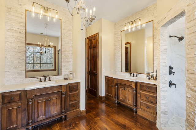 bathroom featuring wood-type flooring, vanity, walk in shower, and a notable chandelier