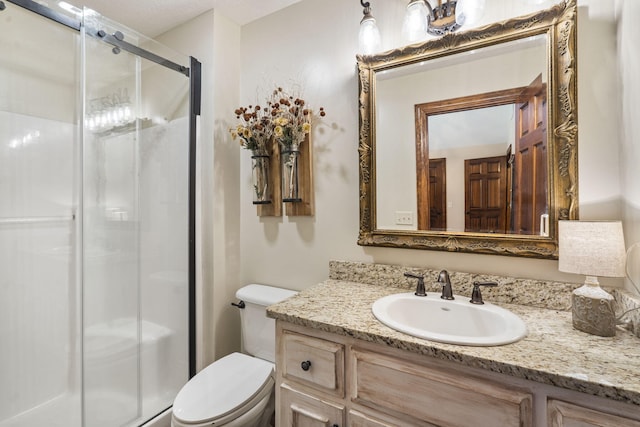 bathroom with vanity, toilet, and a shower with door