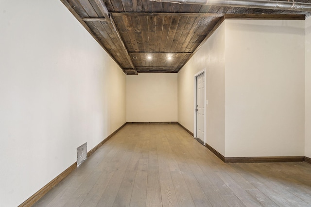 hallway with light hardwood / wood-style flooring and wood ceiling