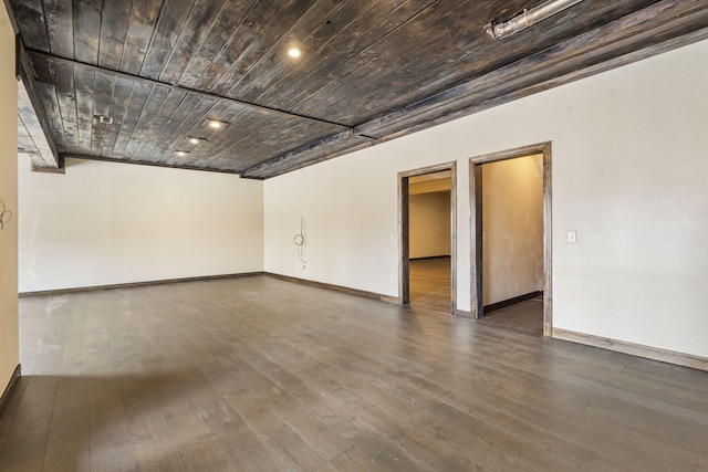 unfurnished room with dark wood-type flooring and wood ceiling