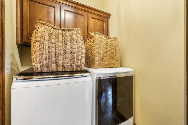 washroom featuring washing machine and clothes dryer and cabinets