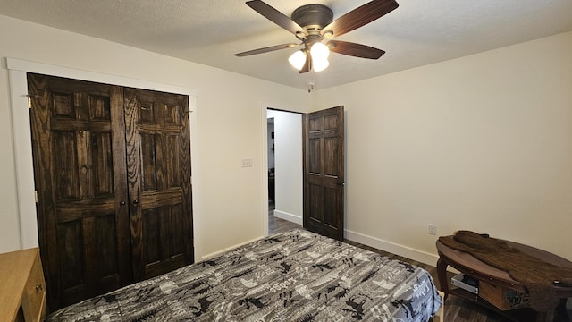 bedroom with ceiling fan, baseboards, a closet, and a textured ceiling