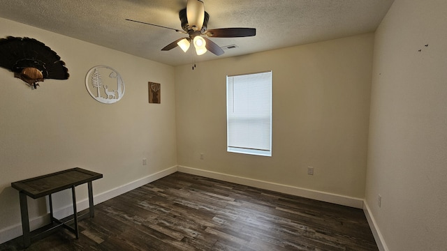 unfurnished room featuring visible vents, dark wood-type flooring, baseboards, ceiling fan, and a textured ceiling