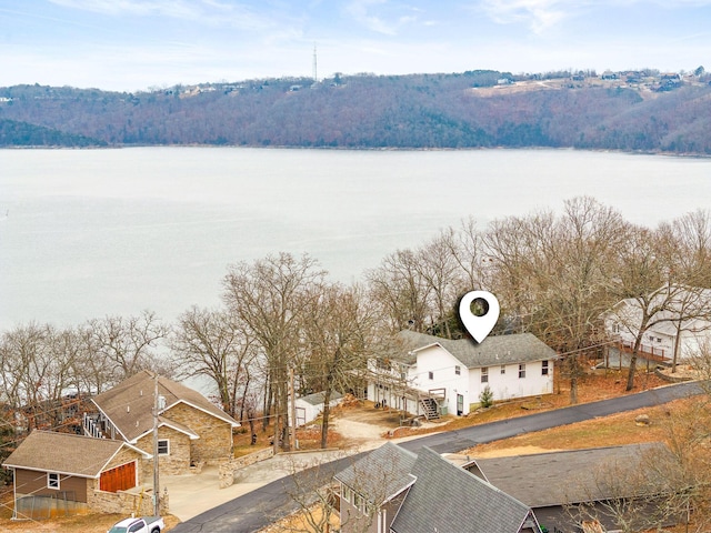 bird's eye view with a water view and a wooded view