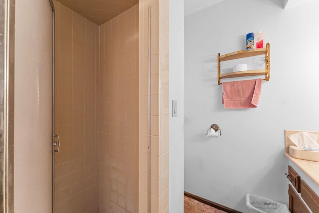 bathroom featuring a stall shower, baseboards, and vanity