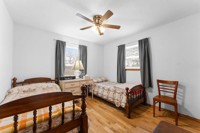 bedroom featuring a ceiling fan, light wood-type flooring, and baseboards