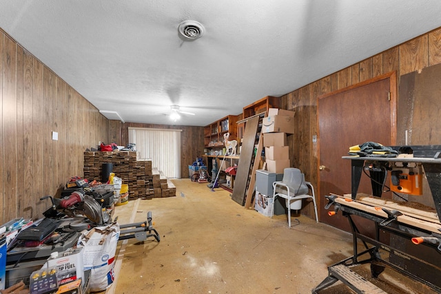 miscellaneous room with wooden walls, visible vents, and a textured ceiling