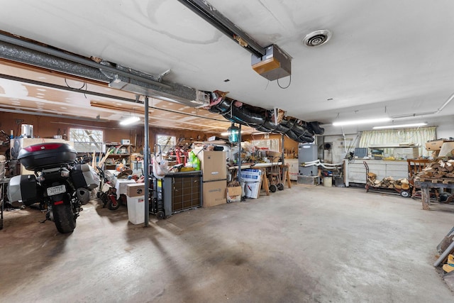 garage featuring visible vents, a workshop area, and a garage door opener