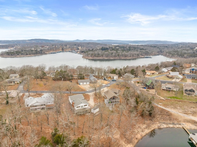 aerial view featuring a wooded view and a water and mountain view