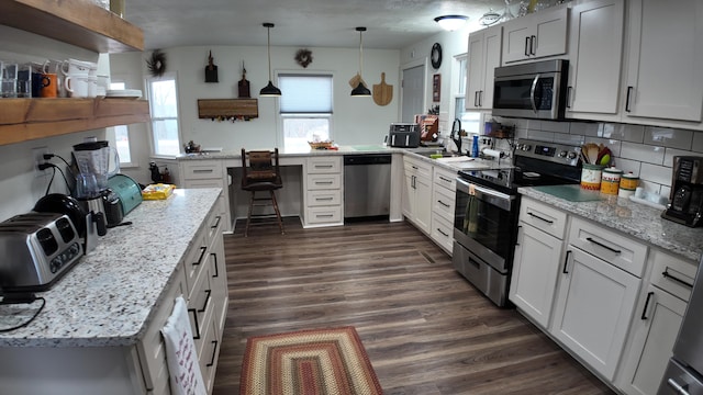 1247 State Hwy N, Clever, MO 65631 - kitchen featuring appliances with stainless steel finishes, dark wood-style flooring, backsplash, pendant lighting, and light stone counters