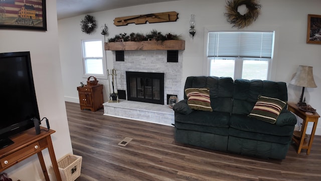 living room featuring dark hardwood / wood-style floors and a brick fireplace