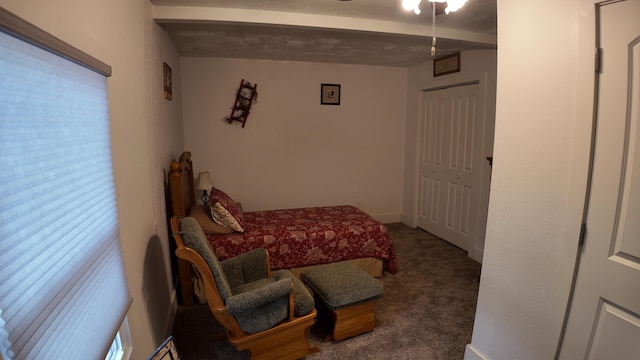 bedroom with carpet, beamed ceiling, and a closet