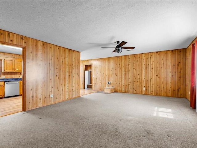 empty room featuring ceiling fan, light colored carpet, and a textured ceiling