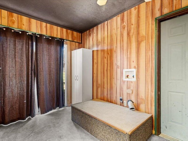 bathroom with concrete flooring and wooden walls