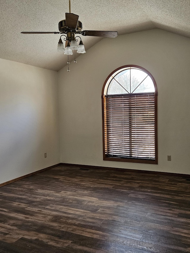 unfurnished room with a textured ceiling, dark hardwood / wood-style flooring, vaulted ceiling, and ceiling fan