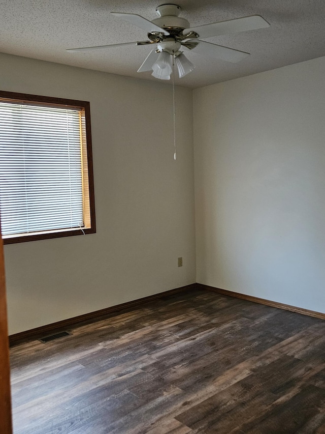 empty room featuring a textured ceiling, dark hardwood / wood-style flooring, and ceiling fan