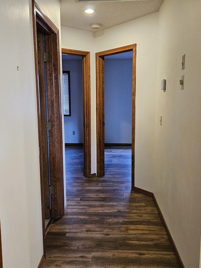 hall with dark hardwood / wood-style flooring and a textured ceiling