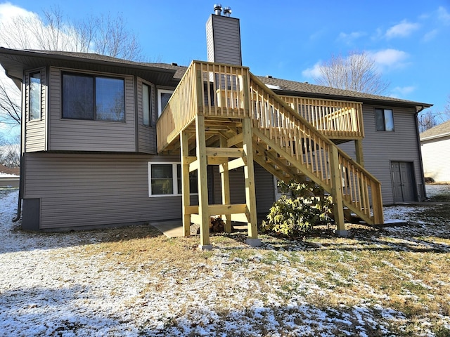 snow covered house with a wooden deck