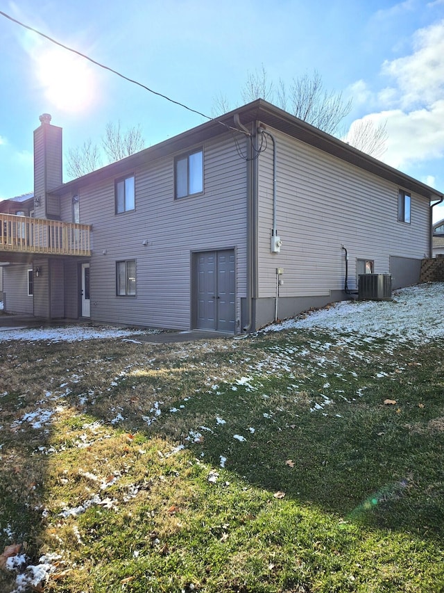 rear view of house with a lawn and central air condition unit